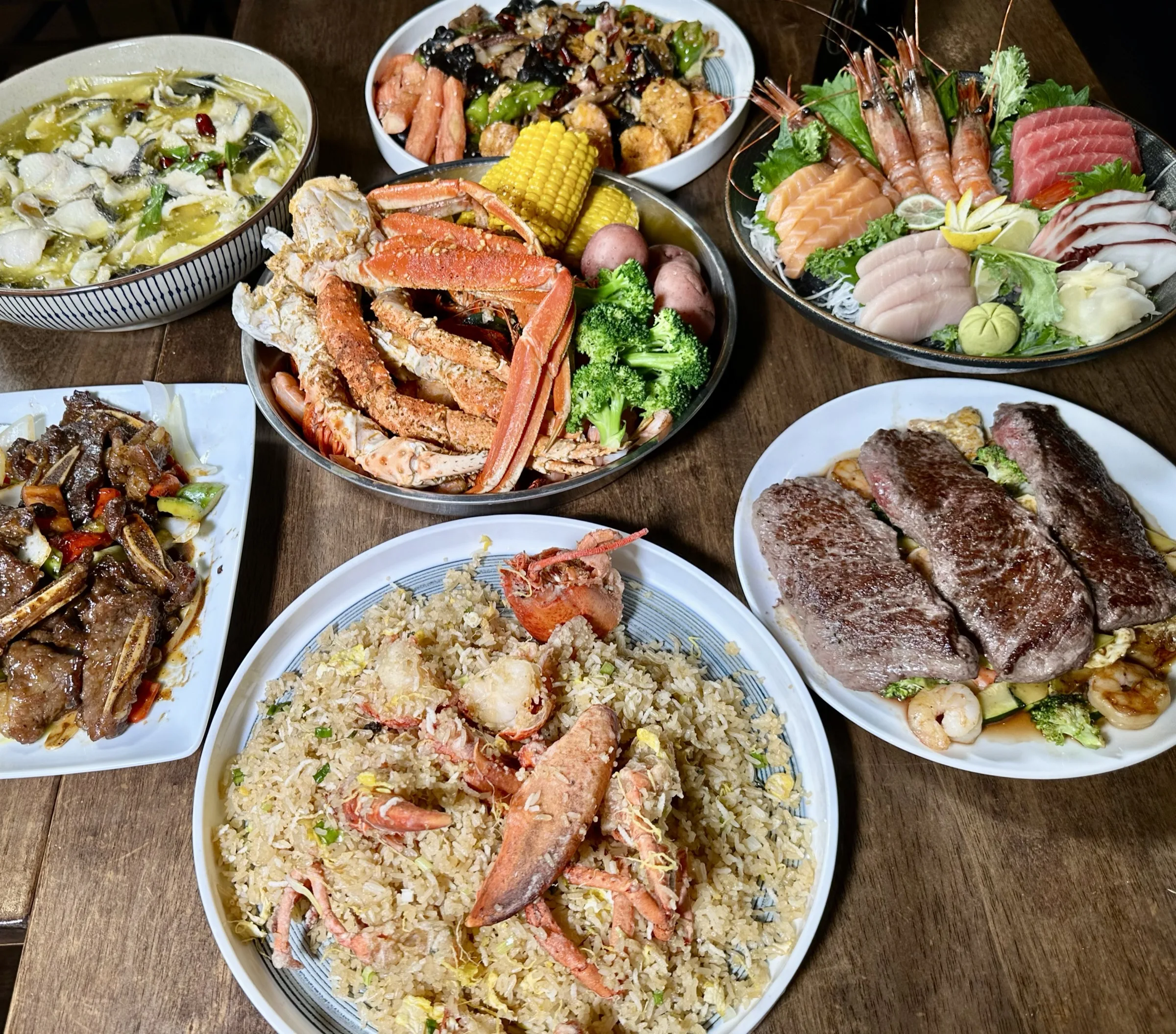 Table spread with crab legs, sashimi, lobster fried rice, and steak at Kumo Ultimate, Stamford CT
